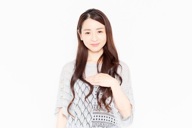 胸に手を当てる女性